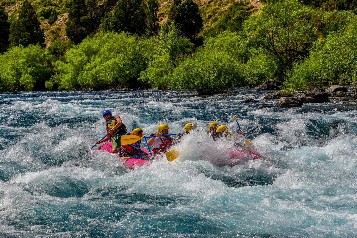 A raft crew paddling through white water on a Patagonian river